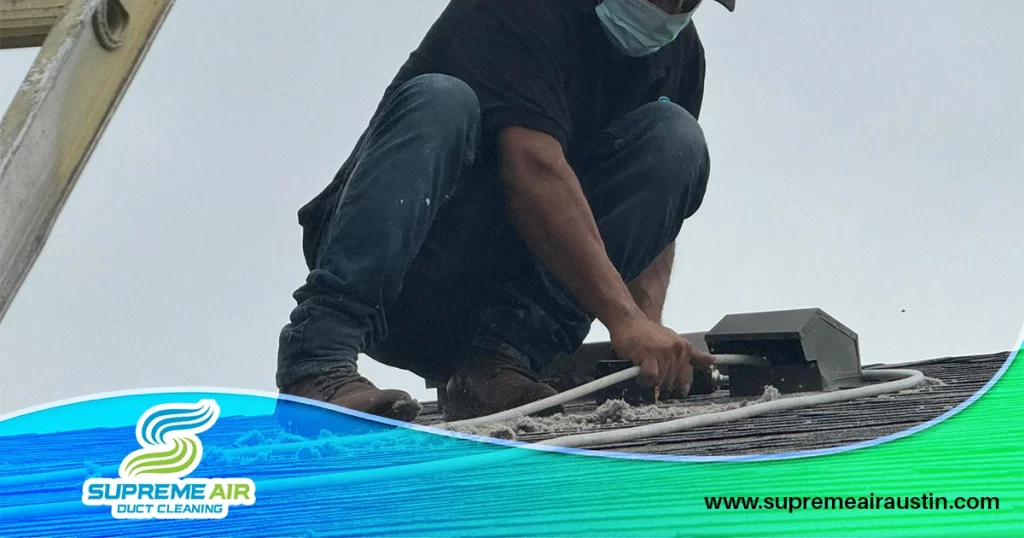 An image shows a technician removing clogged dust, mold, and other debris from the vents on top of the roof.